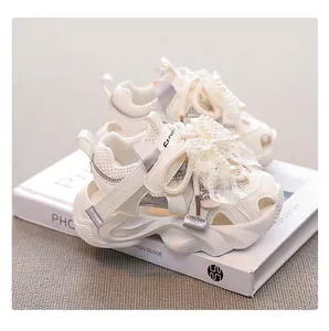 Close-up detail of cream mesh girl's sports sandals featuring a pearl lace bow accent