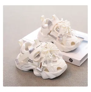 Detail view of girls' white summer mesh sandals featuring elegant lace bow and pearl accents