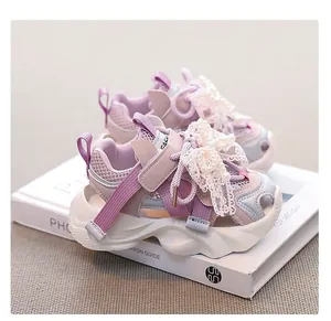 Close-up of pink girls mesh sneakers with elegant lace and pearl bow detail