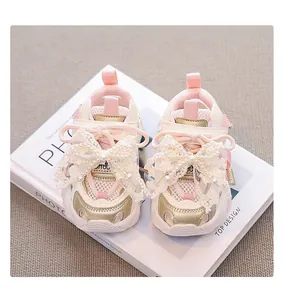 Close-up detail of pink mesh girl's sneakers featuring large lace bows and faux pearls.