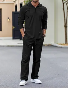 Detail view of men's black waffle knit hoodie and pants set in a stylish outdoor setting