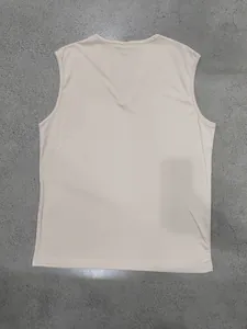 Back view detail of a beige V-neck dry-fit men's training tank top on grey floor.