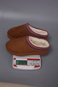 Faux fur lined brown suede slippers weighing 0.424kg displayed on a digital scale.