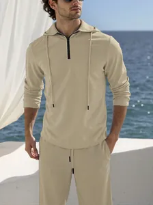 Close-up of men's beige textured linen set with hooded zipper top in seaside setting