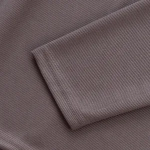 Gros plan sur la texture du tissu en maille côtelée et le poignet d'un polo homme.