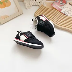 Detaillierte Nahaufnahme der schwarz-weißen Baby-Lauflernschuhe mit Klettverschluss