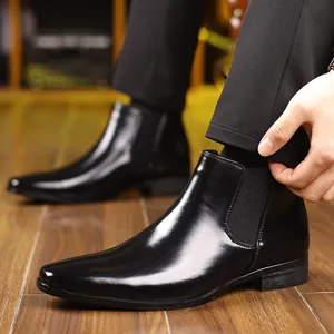Gedetailleerde close-up van gepolijste zwarte Chelsea-boots met een nette heren pantalon