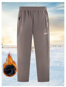 Detailansicht der taupefarbenen Herren-Outdoor-Hose aus doppelseitigem Polarfleece im Schnee
