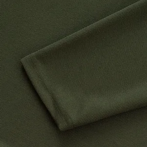 Gros plan d'un poignet de manche en tricot côtelé vert olive foncé pour polo homme.