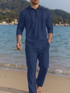 Macro detail of men's navy blue linen hoodie and trousers set in outdoor setting