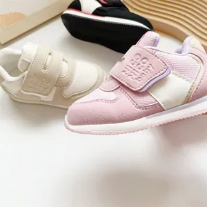 Nahaufnahme von rosa und beigen Kleinkinder-Sneakern mit Klettverschluss und Netz