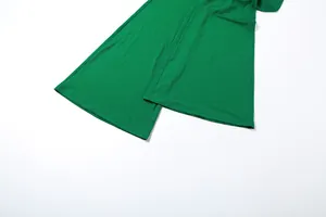 Detailansicht der weiten Beinsäume eines sexy grünen rückenfreien Jumpsuits für Damen im Herbst