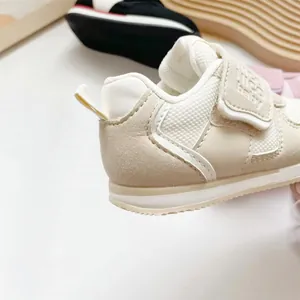 Detail eines atmungsaktiven beigefarbenen Baby-Lernlaufschuhs mit Klettverschluss.