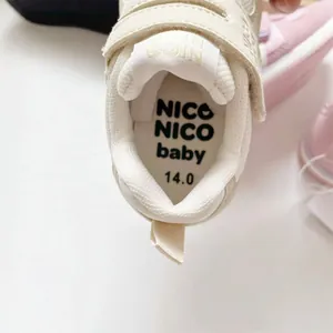 Nahaufnahme von atmungsaktiven cremeweißen Kleinkinderschuhen mit NICO NICO Sohle