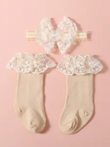 Elegante diadema con lazo de encaje y calcetines altos con volantes para bebés