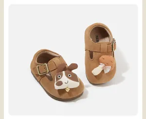 Close-up detail of brown suede baby walking shoes featuring cute dog and mushroom patches