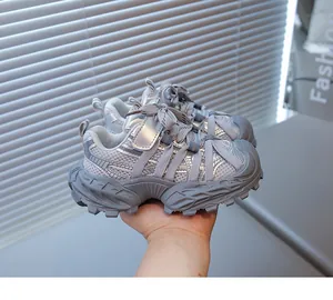 Vue détaillée des baskets chunky grises respirantes pour garçons tenues à la main