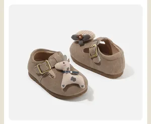 Detail of baby walking shoes with soft sole, brown suede and cute deer ornament.
