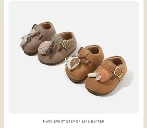 Detail of cute baby walker shoes with cartoon animal decorations in various brown shades