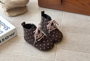 Close-up detail of brown polka dot toddler Martin boots with soft soles and pink laces