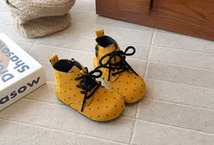 Close-up detail of yellow polka dot girls' Martin boots with side zipper and black laces