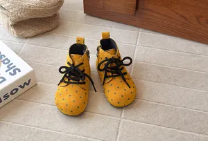 Detailed view of yellow polka dot suede Martin boots for girls featuring soft soles