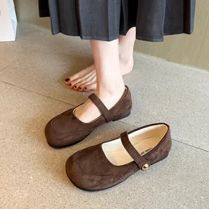 Chaussures Mary Jane en daim marron portées avec une jupe plissée grise au style français