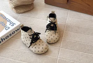 Detail view of beige polka dot baby boots with side zipper and round toe design