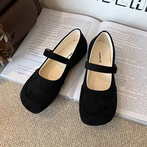 Gros plan de ballerines Mary Jane en daim noir avec bride sur fond de livre ouvert élégant