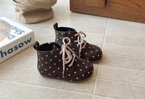 Detailed side view of toddler brown boots with pink polka dots and soft soles for girls