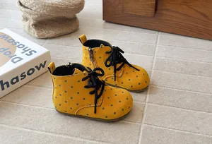 Detailed side view of yellow polka dot children's Martin boots featuring side zipper