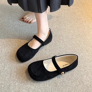 Vue détaillée de chaussures Mary Jane en daim noir avec bride à bouton doré.