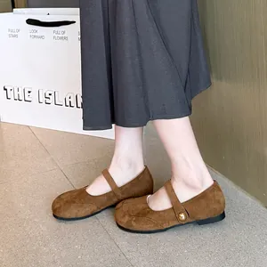 Vue latérale d'élégantes ballerines Mary Jane en daim marron avec bouton doré décoratif