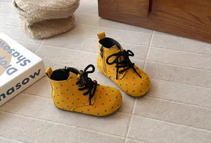 Detailed macro view of yellow polka dot toddler Martin boots in a cozy lifestyle scene.