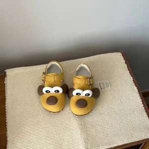 Cute yellow children's shoes with dog face design and plush warm lining details.