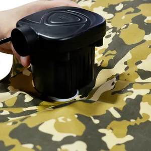 Close-up of a black electric air pump inflating a durable camouflage vacuum storage bag