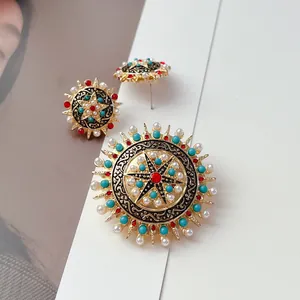 Dettaglio del set di gioielli vintage bohémien con spilla a stella e orecchini di perle.