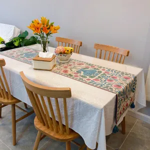Detailed view of elegant white French lace tablecloth on a dining table with chairs