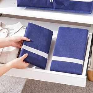 Foldable blue fabric storage bag for clothes and quilts organized in a drawer