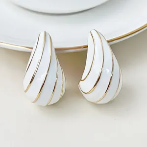 Detail von weißer Emaille-Tropfenohrringe mit elegantem goldfarbenem Linien-Design