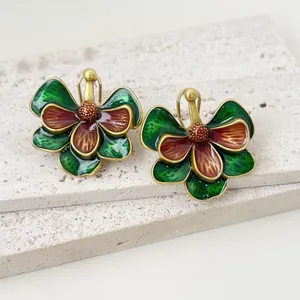 Vue détaillée des boucles d'oreilles fleurs en émail vintage aux couleurs vert et rouge