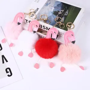 Detailed view of colorful faux fur flamingo pom-pom keychains in pink and white