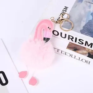 Close-up of pink flamingo pom-pom keychain with faux fur ball for bag decoration