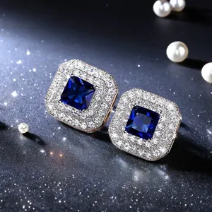 Nahaufnahme von eleganten Ohrsteckern mit blauem Zirkon und funkelndem Heiligenschein