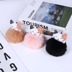 Set aus drei süßen Katzen-Bommel-Schlüsselanhängern aus Kunstfell in Braun, Rosa und Schwarz.