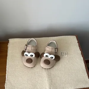 Close-up of cute cartoon dog face design on warm fleece-lined toddler winter shoes