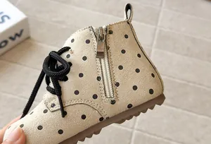 Close-up of polka dot girls' ankle boot with side zipper and soft suede texture