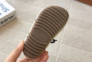 Detailed view showing the brown textured rubber sole on a girls polka dot boot.