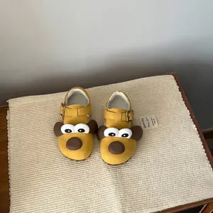 Close-up of yellow children's casual shoes with a cute cartoon dog face design