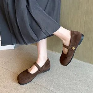 Vue détaillée de ballerines Mary Jane en daim marron avec bride à bouton doré élégante